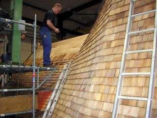 Un couvreur en action sur une toiture de moulin